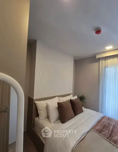 Modern bedroom with stylish decor and cozy ambiance, featuring plush pillows and soft lighting.
