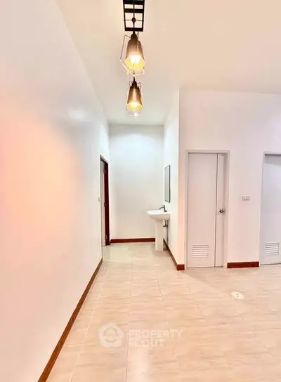 Spacious hallway with modern lighting and sleek tile flooring