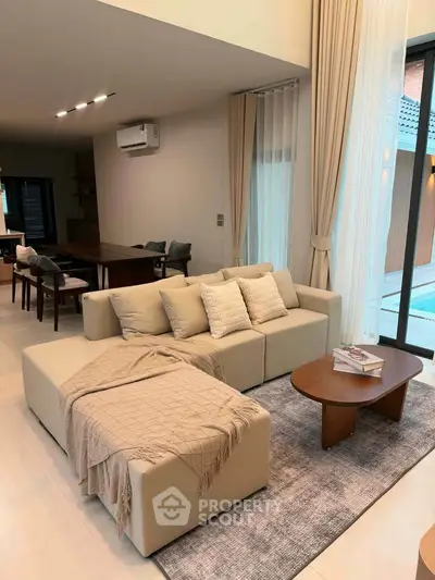 Spacious modern living room with elegant decor and pool view, perfect for luxury living.