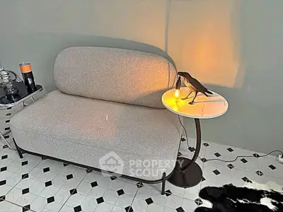 Stylish modern living room with elegant gray sofa and unique side table decor.