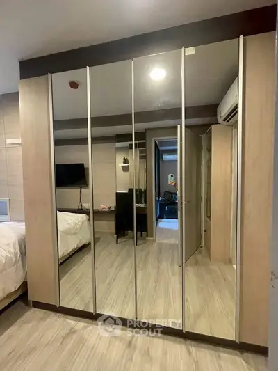 Spacious bedroom with mirrored wardrobe and modern decor