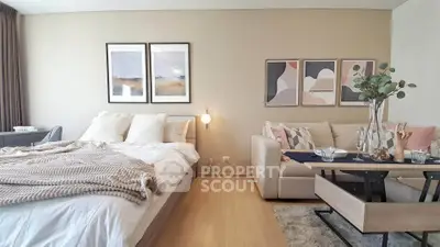 Modern studio apartment with cozy bed and stylish dining area, perfect for urban living.