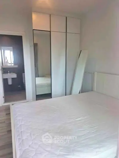 Spacious bedroom with modern wardrobe and ensuite bathroom in a stylish apartment.