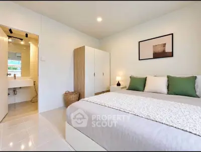 Spacious bedroom with modern decor and ensuite bathroom in a stylish apartment.