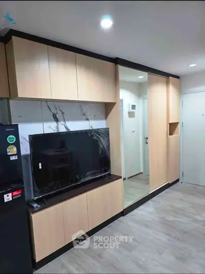 Modern living room with sleek cabinetry and mounted TV in stylish apartment.