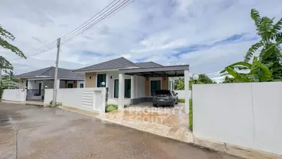 Modern single-story house with carport and lush greenery in a serene neighborhood.