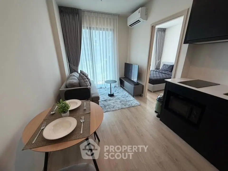 Modern apartment interior with cozy living room and open kitchen layout, featuring stylish furniture and natural light.