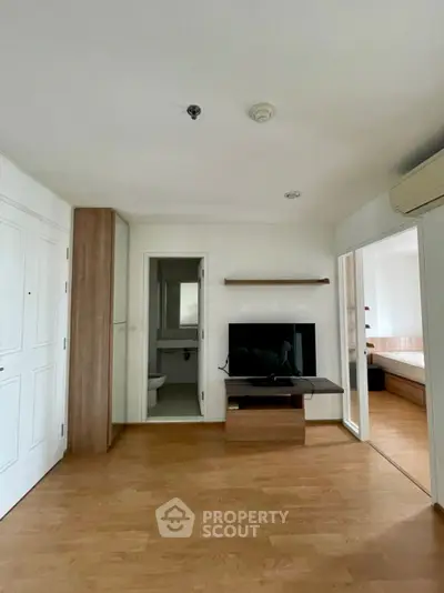 Modern apartment interior with wooden flooring and TV setup