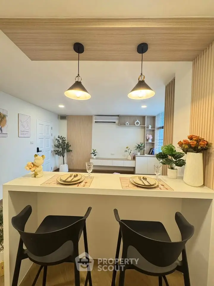 Modern open-plan living room with stylish decor and breakfast bar seating.