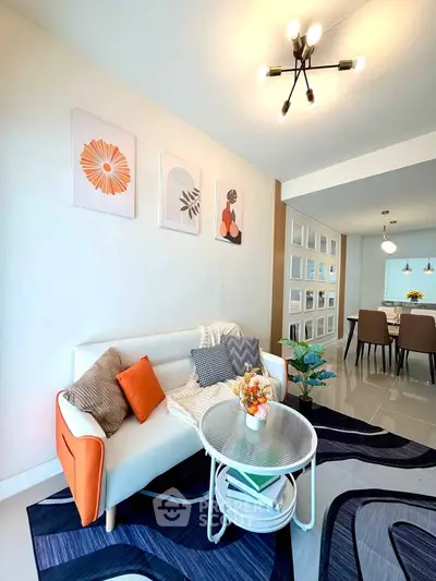 Modern living room with stylish decor and open layout leading to dining area.