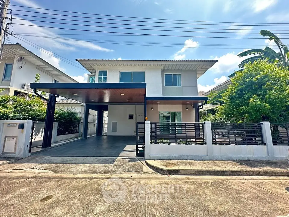 Modern two-story house with spacious driveway and lush greenery in a serene neighborhood.