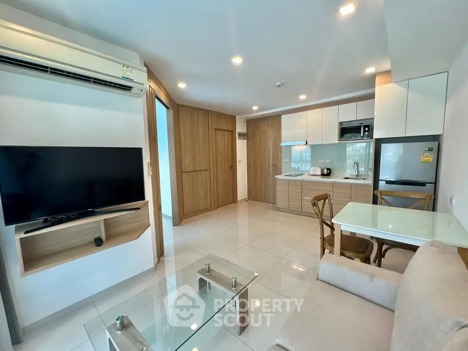 Modern living room with sleek furniture and open kitchen layout in a stylish apartment.