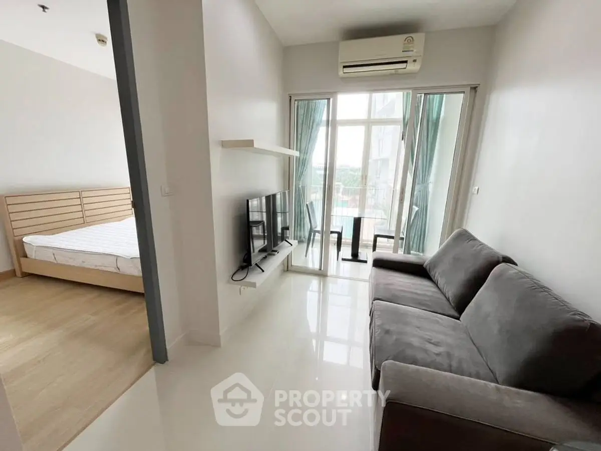 Modern living room with sleek furniture and large windows offering natural light.