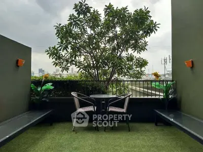 Charming balcony with lush greenery and city view, perfect for relaxation.