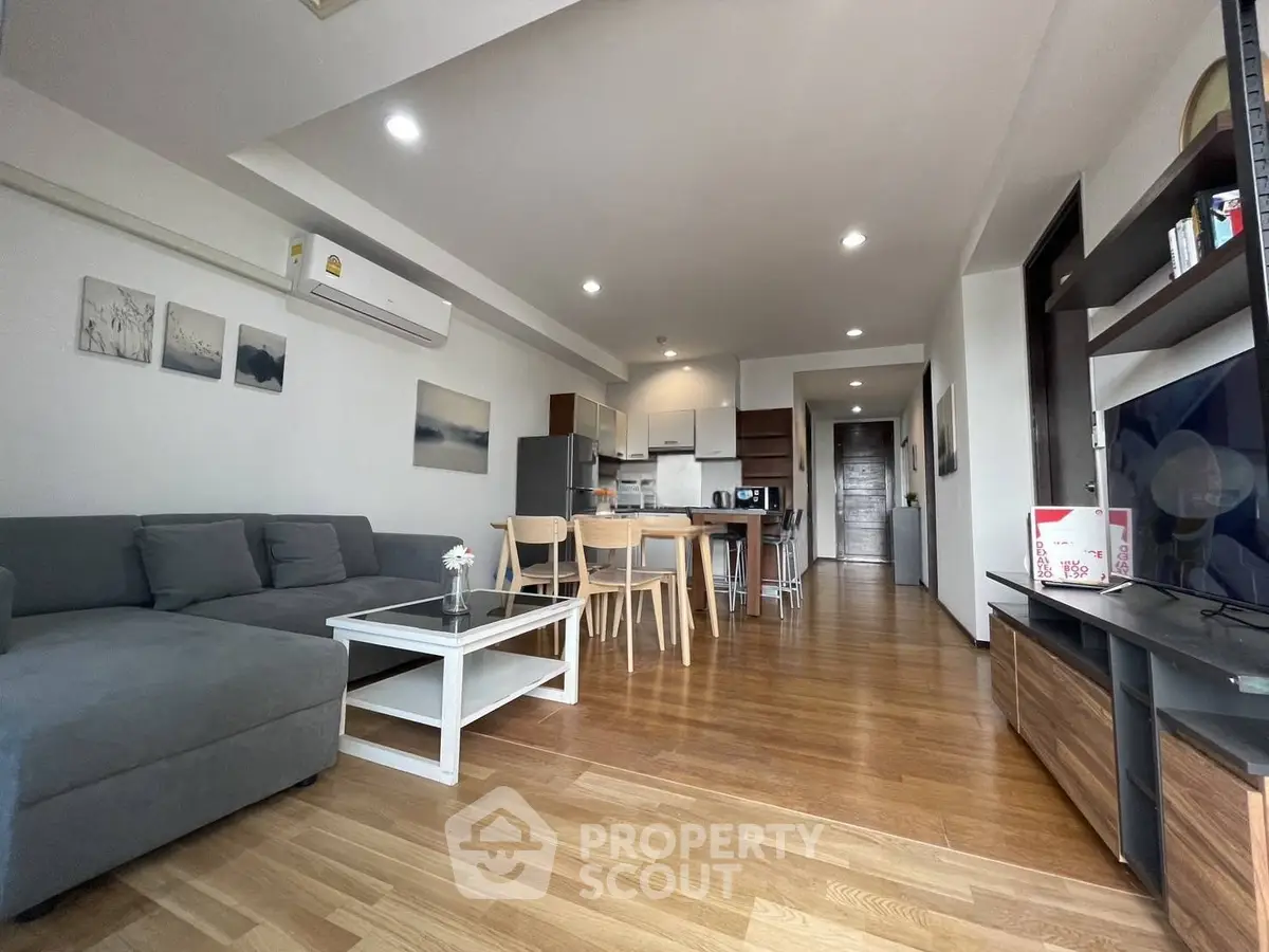 Spacious modern living room with open kitchen and wooden flooring