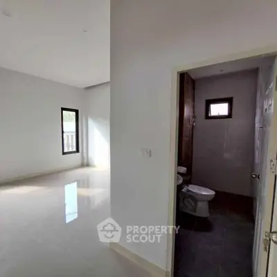 Spacious interior with bright living area and adjacent bathroom, featuring modern design and natural light.
