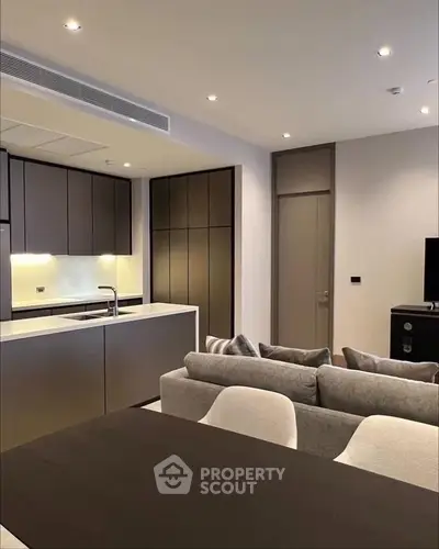 Modern open-plan kitchen and living area with sleek design and neutral tones.