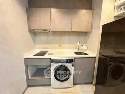 Compact modern kitchen with washing machine and sleek cabinetry