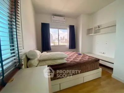 Cozy bedroom with city view, featuring a comfortable bed and modern decor, perfect for urban living.