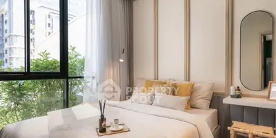 Cozy bedroom with large window and modern decor, offering a serene view of greenery.