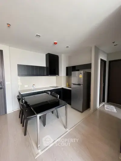 Modern kitchen with sleek black cabinets and dining area in a stylish apartment