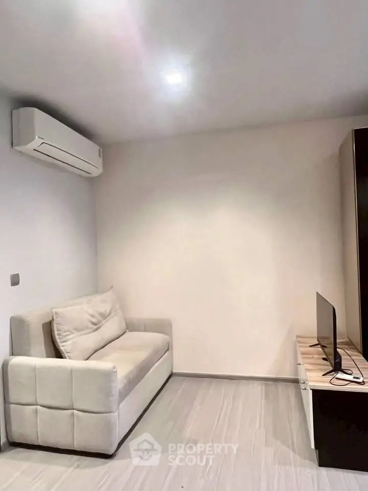 Cozy living room with modern sofa and wall-mounted air conditioner