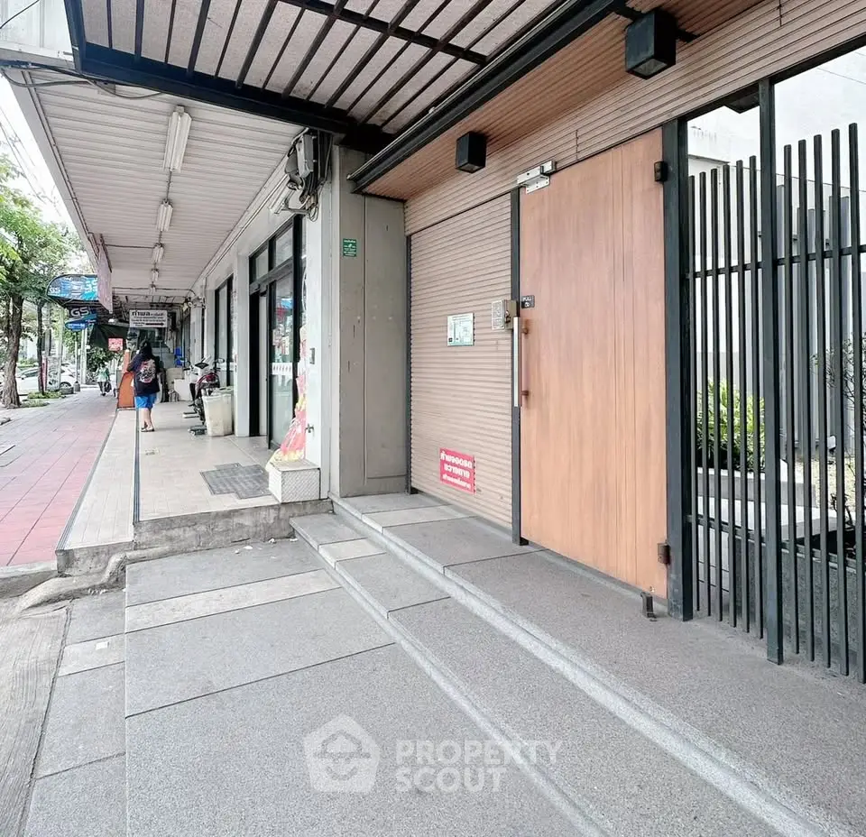 Modern commercial building entrance with sleek design and secure gated access.