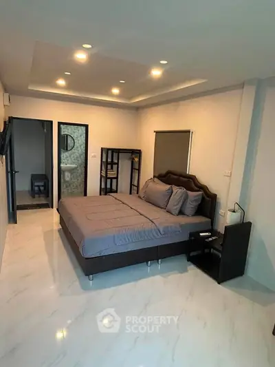 Spacious modern bedroom with ensuite bathroom and elegant lighting