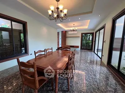 Elegant dining room with wooden table and chairs, marble flooring, and large windows.