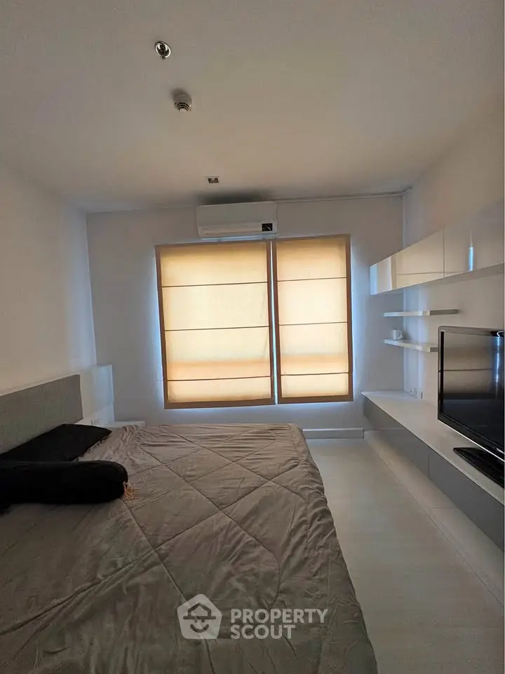 Modern bedroom with sleek design, featuring a large bed, wall-mounted TV, and stylish window shades.