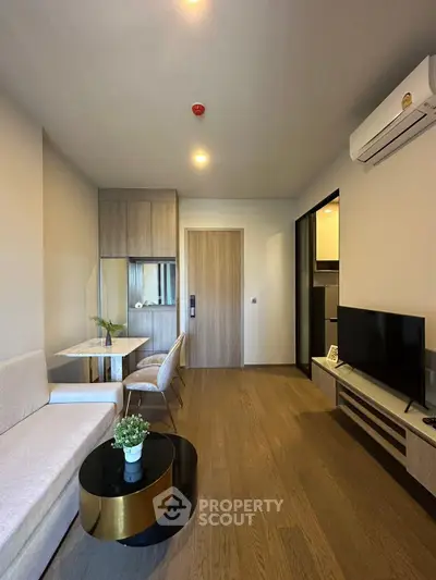 Modern living room with sleek furniture and wooden flooring in a stylish apartment.
