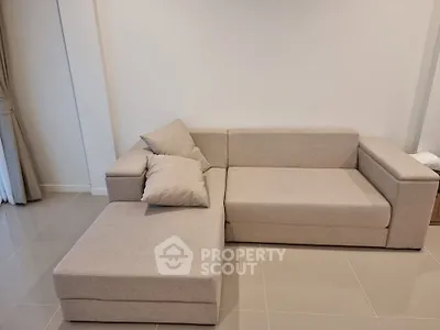 Modern living room with stylish beige sectional sofa and elegant tile flooring.