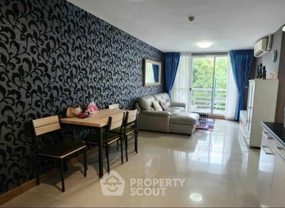 Spacious living room with elegant wallpaper and modern furniture, featuring a cozy dining area and large windows.
