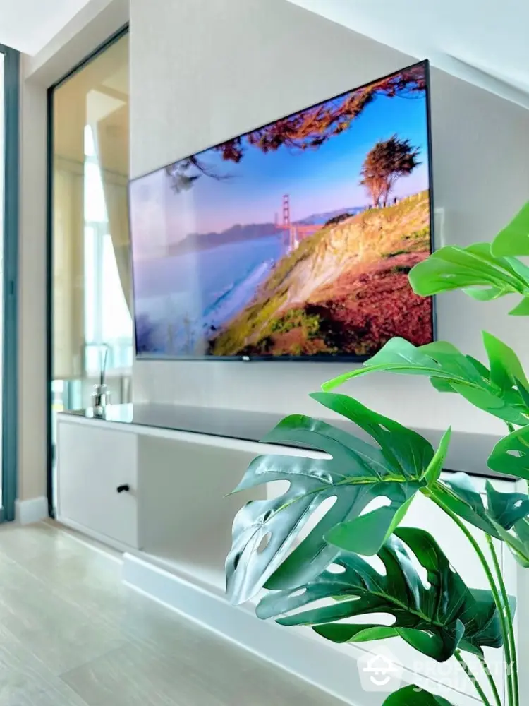 Modern living room with wall-mounted TV and lush indoor plant