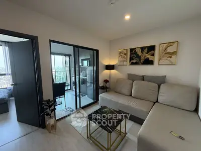 Modern living room with stylish decor and balcony view in a contemporary apartment.