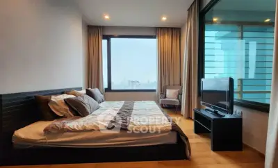 Spacious modern bedroom with large window and city view, featuring a cozy bed and sleek TV setup.