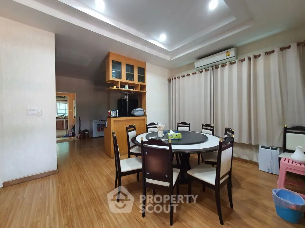 Spacious dining area with elegant wooden flooring and modern decor