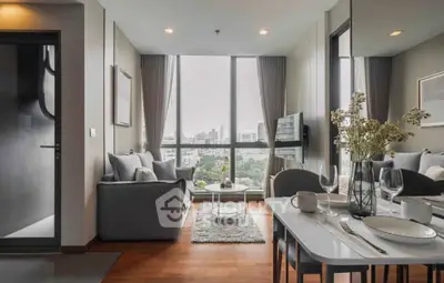 Modern living room with city view, elegant decor, and cozy seating area.