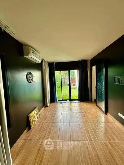 Spacious room with garden view and modern decor, perfect for relaxation and comfort.