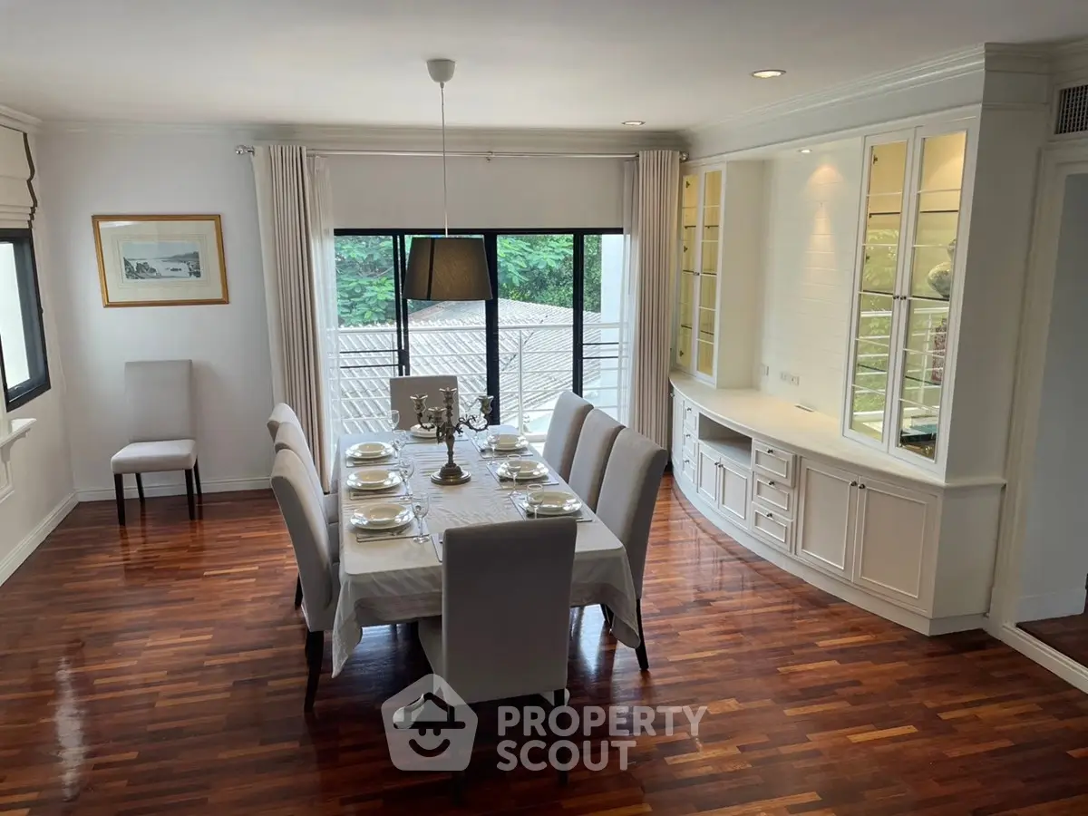 Elegant dining room with hardwood floors and large windows offering natural light.