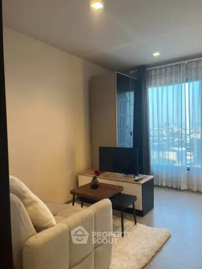 Cozy living room with modern decor and city view through large window.