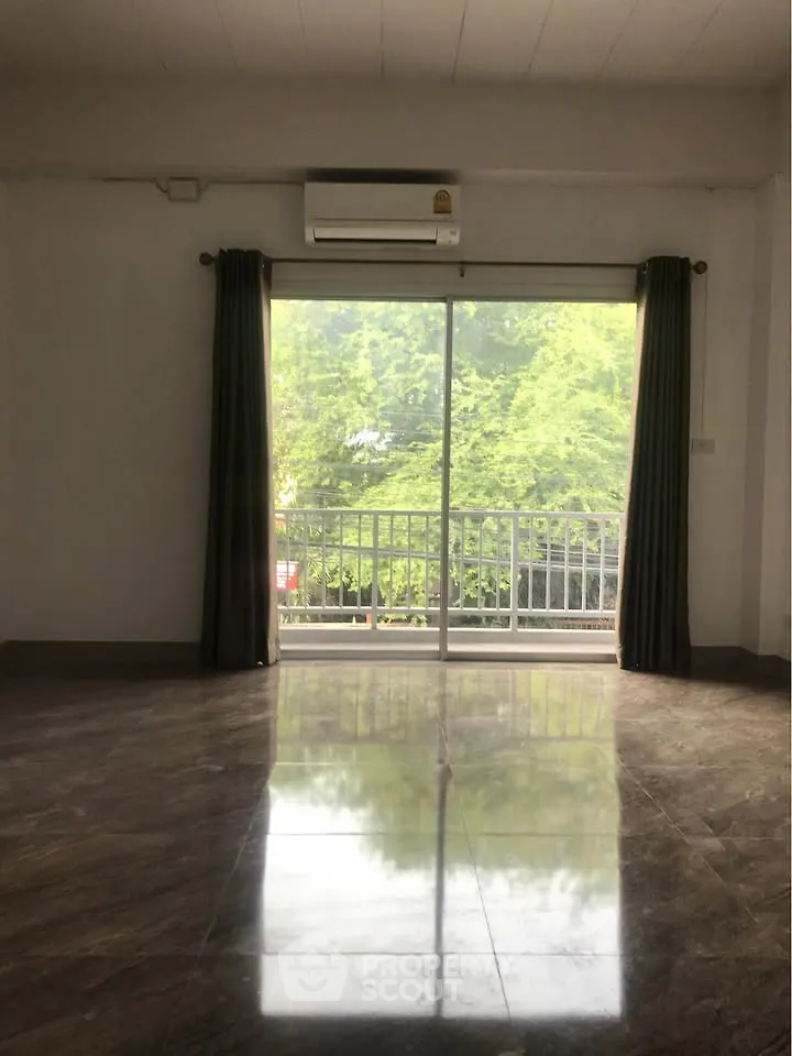 Spacious living room with large window and balcony view