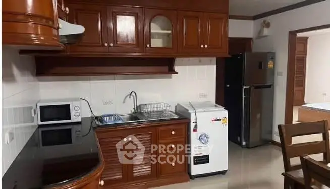 Spacious kitchen with wooden cabinets and modern appliances in a cozy home.