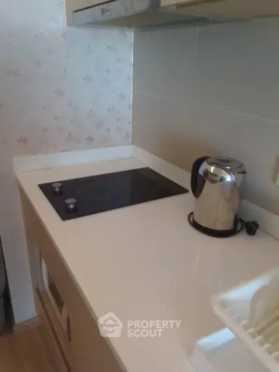 Modern kitchen with sleek electric stove and stainless steel kettle