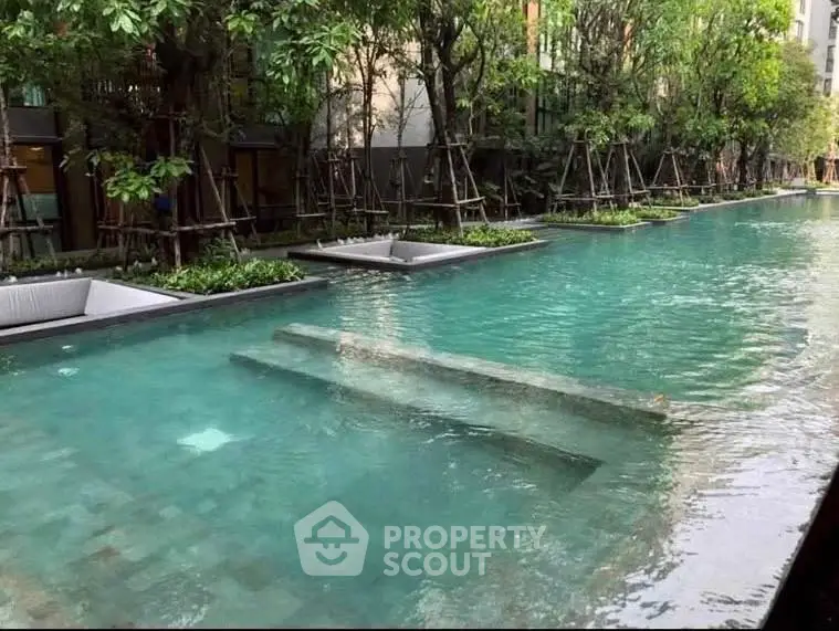 Luxurious residential pool surrounded by lush greenery, perfect for relaxation and leisure.