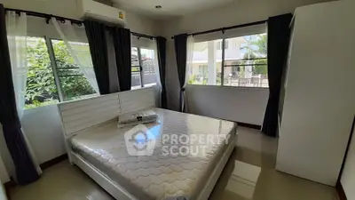 Bright and airy bedroom with large windows and modern furnishings