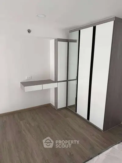 Modern bedroom with sleek wardrobe and wooden flooring