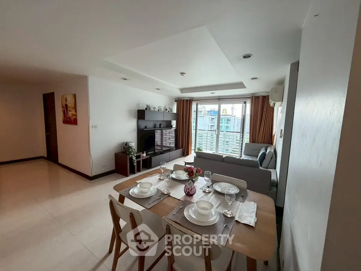 Spacious living room with dining area and city view, perfect for modern living.