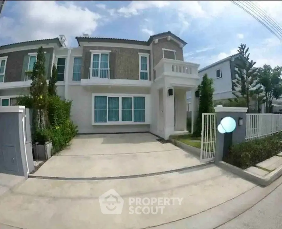 Modern two-story house with spacious driveway and lush greenery