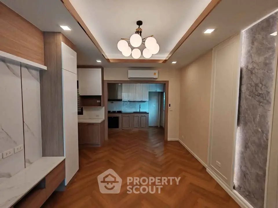 Modern open-plan living room with elegant lighting and wood flooring